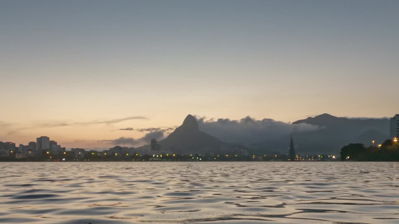 lapso de tiempo de la puesta de sol en el lago de la ciudad en río de janeiro con el árbol de navidad flotante encendiendo sus luces al final