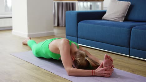 woman practicing yoga split pose hanumanasana at home