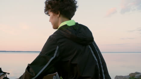 atletische vrouw in sportkleding die hun benen strekt voordat ze gaat trainen op de promenade langs het meer bij zonsopgang