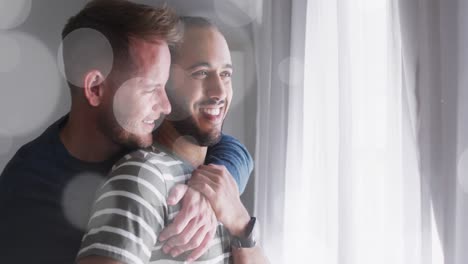 Animation-of-light-spots-over-diverse-male-couple-embracing