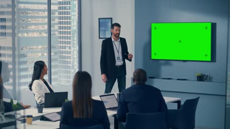 presentación de la reunión en la sala de conferencias de la oficina: el hombre de negocios guapo habla, usa pantalla verde chroma key wall tv. presentación exitosa del producto de comercio electrónico a un grupo de inversores multiétnicos