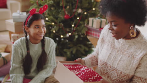 joyous black woman receiving xmas gift from family