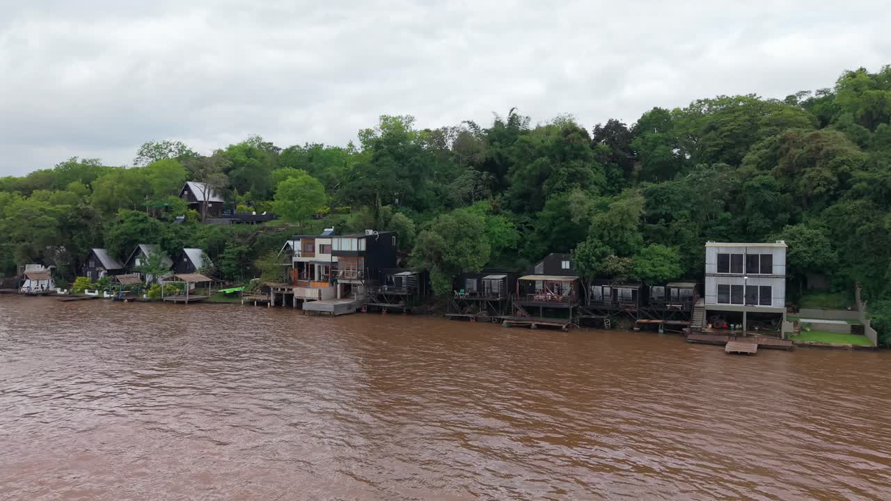 Riverside houses and glampings surrounded by lush green forest on the Paraná River, Puerto Lagier, Misiones, Argentina