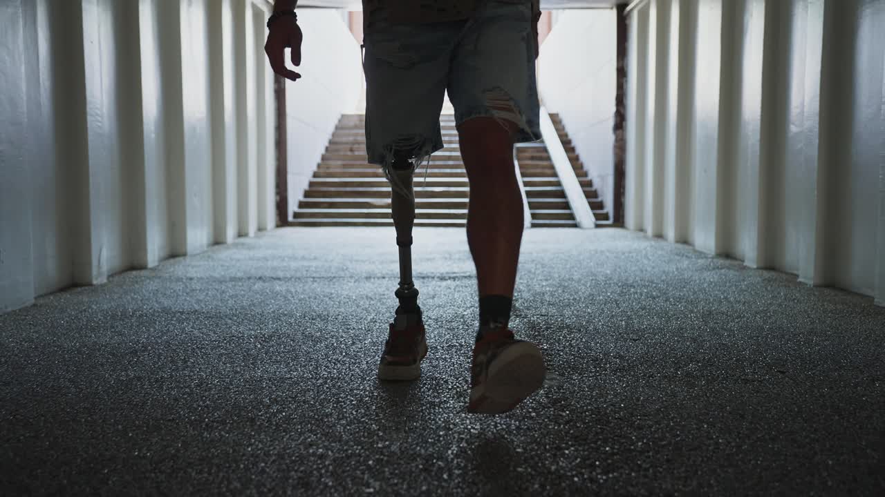 Person with a Prosthetic Leg Walking Through an Underground Passage