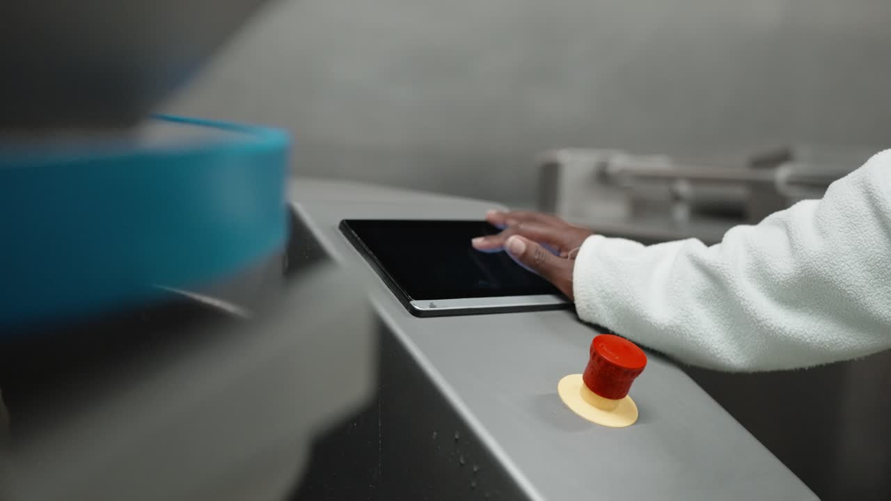 Close up of hand operating touchscreen panel on industrial equipment