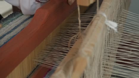 weaver makes fabric in ethnic loom