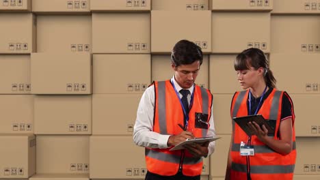 animación de trabajadores de almacén masculinos y femeninos usando tableta con pilas de cajas en el fondo