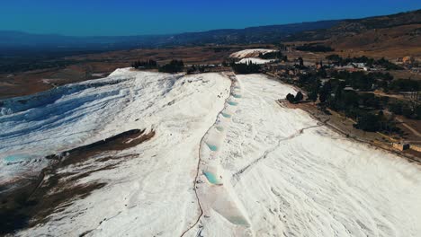 4K-Drohnenvideo-Aus-Der-Luft-Einer-Touristenattraktion-In-Pamukkale,-Eines-Natürlichen-Pools-Mit-Blauem-Wasser-Und-Kalkhaltigen-Mineralien-Aus-Der-Türkei