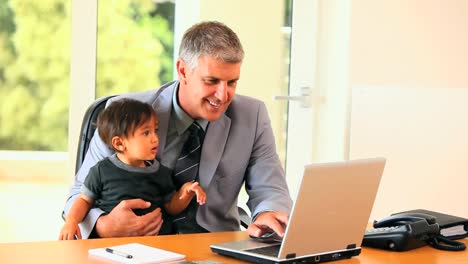 baby helping father with laptop