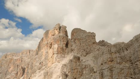 drone ascends lagazuoi mountain, italian dolomites, skimming the rocky ridge through clouds