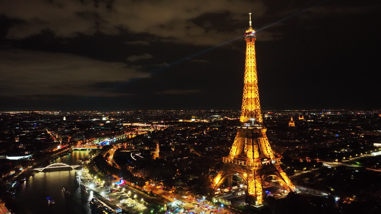 Cinematic drone shot of iconic Eiffel tower illuminated with night light, Paris