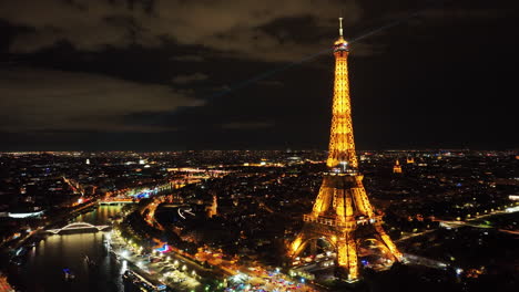 cinematic drone shot of iconic eiffel tower illuminated with night light, paris