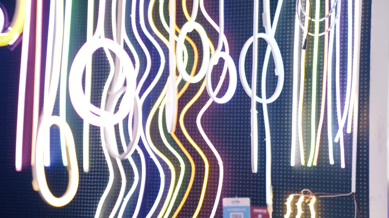 largas luces de cuerda coloridas cuelgan en la tienda que vende guirnaldas, tubos de neón y leds