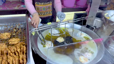 vendor frying peanuts at floating market stall