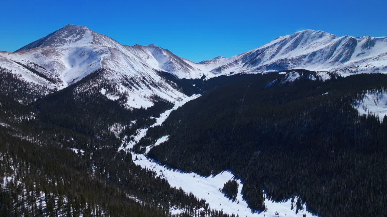 Boreas Mountain Pass Breckenridge Colorado aerial drone cinematic backcountry sunny blue clear sky North Fork Tiger Road Bald Rocky Mountains winter fresh snow snowmobile circle right