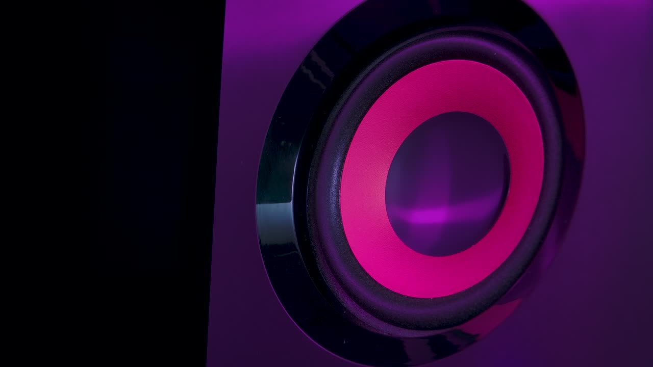 altavoces de audio iluminados por coloridas luces de neón del club. altavoz de subwoofer de estudio profesional aislado. concepto para fiesta de música de baile. up close. cámara lenta