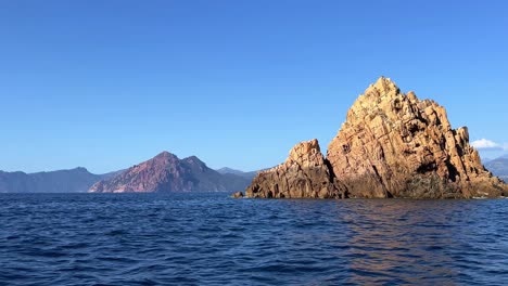 navegando a gran velocidad a lo largo de las formaciones rocosas volcánicas de calanques de piana en la isla de córcega en la temporada de verano, francia