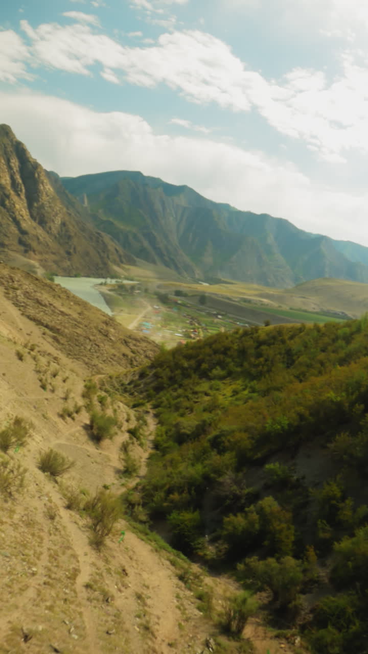 Deep ravine between mountain and forest fpv drone. Majestic hollow and trail lines on hills slopes under cloudy sky. Picturesque highland scene
