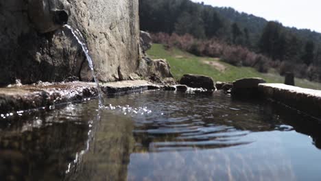 frisches, sauberes wasser in einem natürlichen brunnen auf einem berg