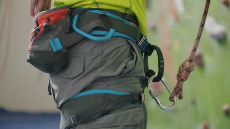 climber attaching a belay rope and chalking hands.