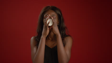 woman takes a big drink from cup