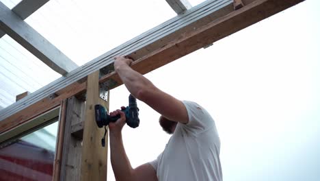 A-Man-is-Building-the-Framework-for-a-Greenhouse-in-Indre-Fosen,-Trondelag-County,-Norway---Close-Up