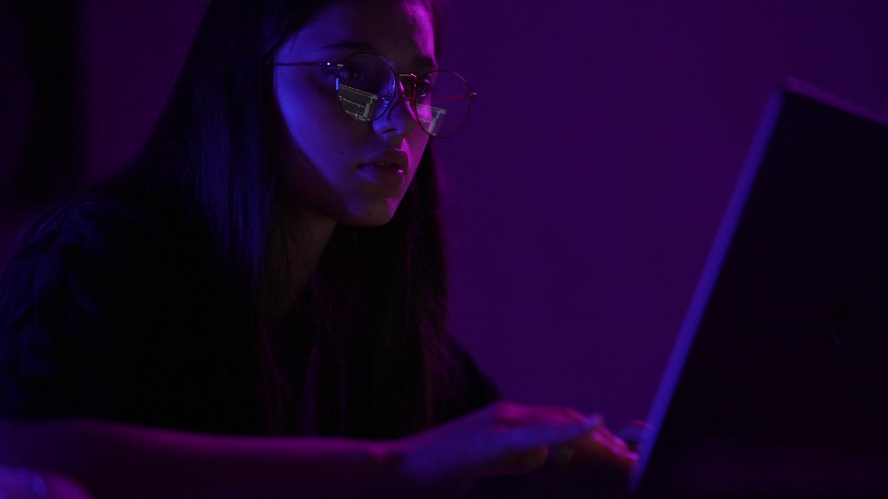 Teenager working on laptop at night