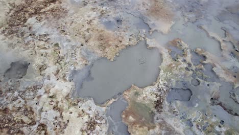 Vista-Aérea-Inclinada-Hacia-Arriba-Sobre-El-área-Geotérmica-De-Hverir-Con-Agua-Hirviendo-En-Islandia