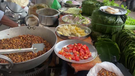 Ein-Korb-Eines-Mobilen-Chana-Chaat-Verkäufers-Mit-Ausgestellten-Tomaten-,-Zwiebel--Und-Sal-Blättern