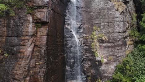 una pequeña corriente de agua cae en cascada sobre la cascada de salto de los amantes de altura casi cuadrada entre la naturaleza verde en la jungla asiática de sri-lanka