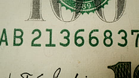 close-up of a us 100 dollar bill serial number