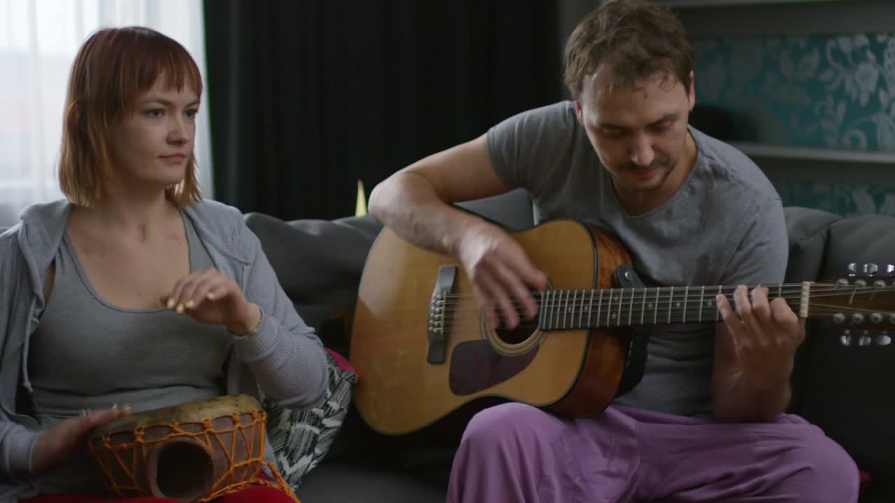 pareja tocando música en casa