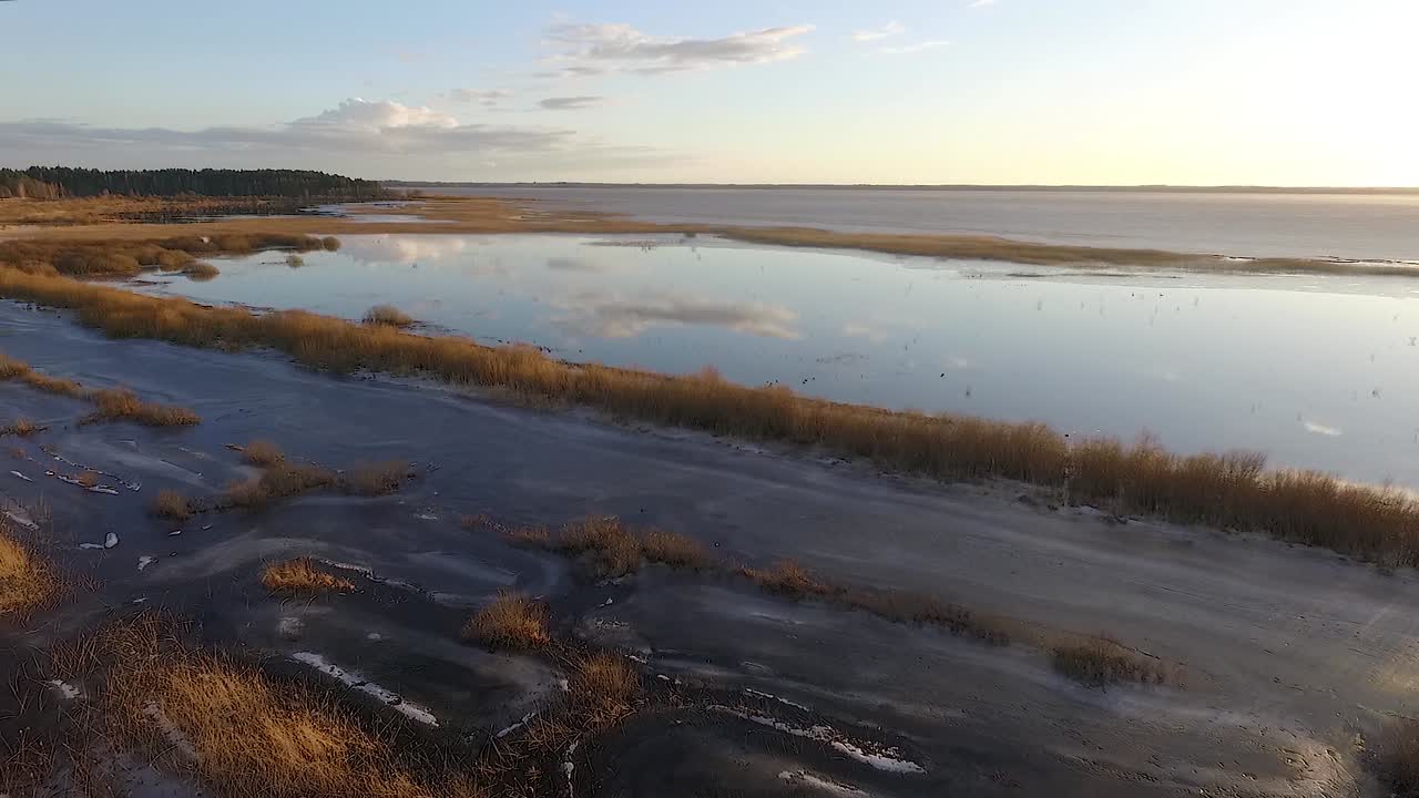 lago tranquilo burtnieks con poco hielo y alto nivel de agua en vista aérea de primavera