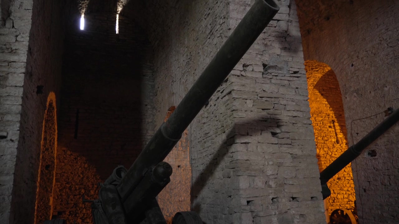 Esposizione di artiglieria della Guerra Fredda all'interno delle camere a volta in pietra della Fortezza di Argirocastro, Albania.