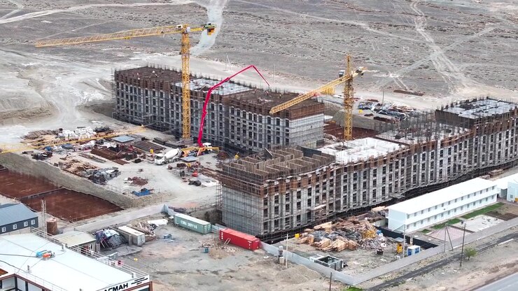 Huge hotel buildings or apartment construction site with cranes in Balykchy, Kyrgyzstan drone