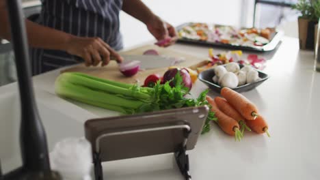 mid section of african american woman preparing dinner in kitchen