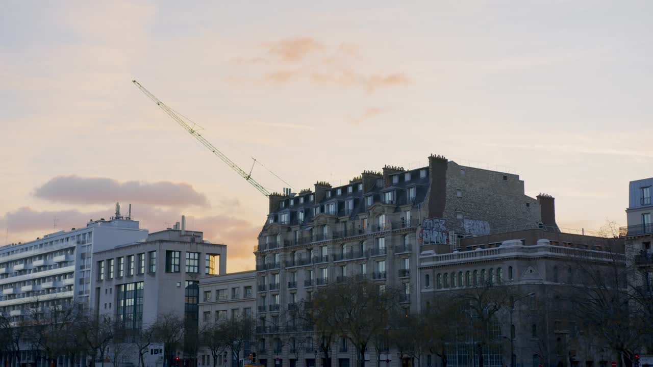 Paris Skyline with Crane Over Haussmann Buildings at Sunset