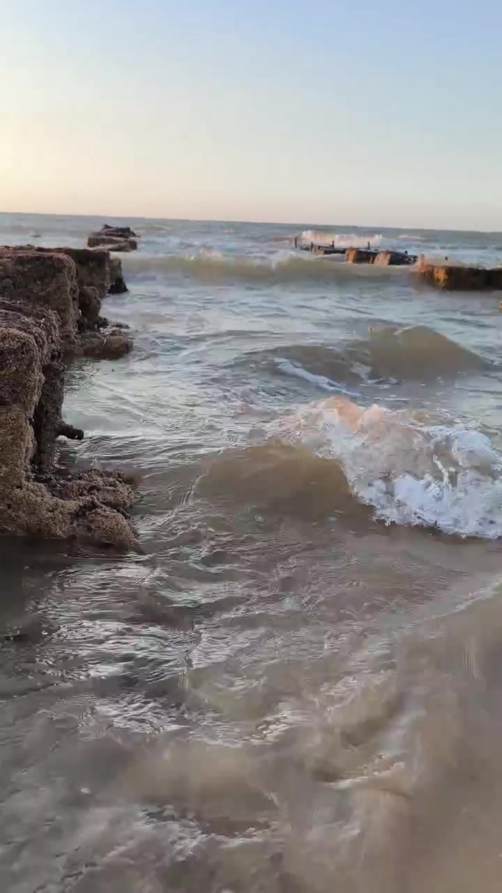 Le onde dell'oceano lavano dolcemente la spiaggia sabbiosa al tramonto