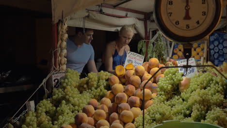 pareja eligiendo tomates en el mercado callejero