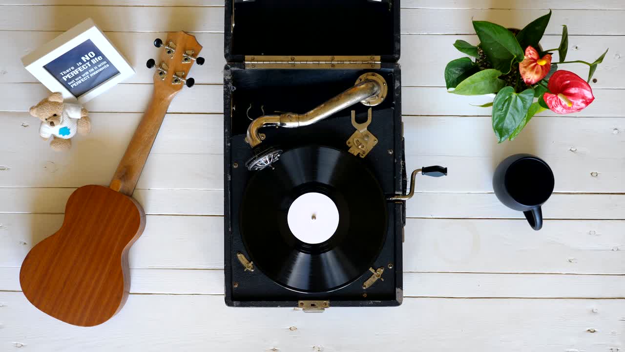 색 나무 테이블에서 오래된 그래모폰을 재생하는  뷰, 빈티지 턴테이블에서 회전하는 비닐 레코드, 레트로 컨셉, 위에서 찍은 슬로 모션 클로즈업