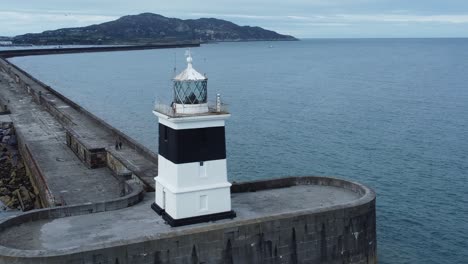 Holyhead-breakwater-lighthouse-longest-concrete-coastal-sea-protection-landmark-aerial-view-slowly-rising