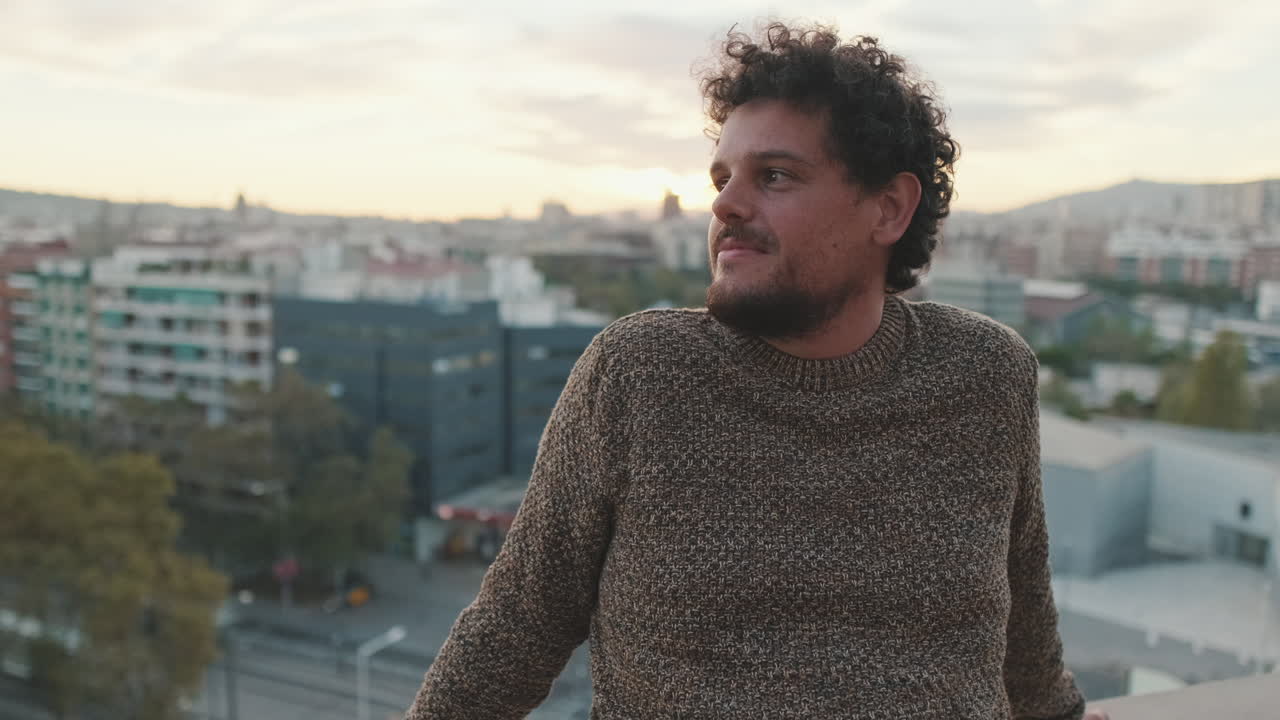 Hombre contemplando el paisaje urbano desde la azotea