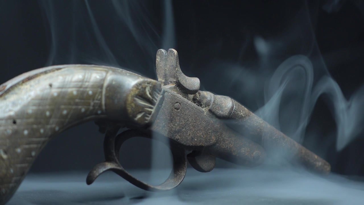 Pistola antica avvolta da fumo bianco
