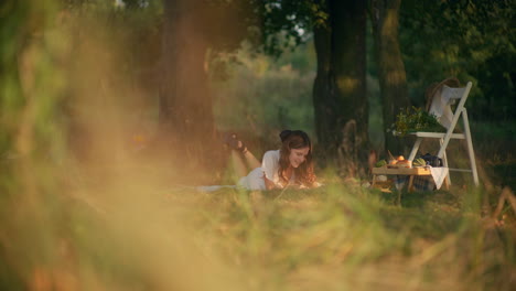 dreamy girl lying in grass at summer picnic