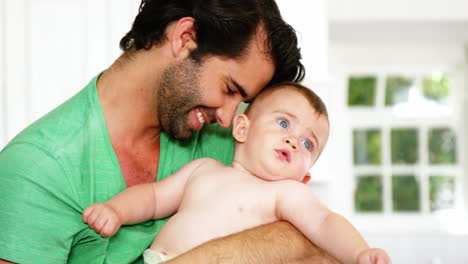 Happy-father-smiling-and-giving-a-hug-to-his-baby