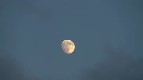 clouds slowly passing by big moon in the sky