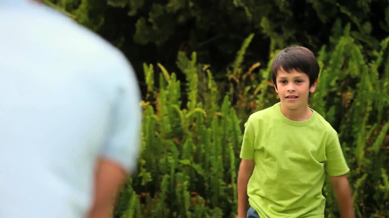 작은 소년 이 아버지 와 함께 공 을 치고 있다