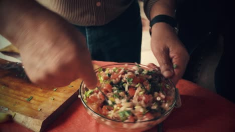 chef mixing all the vegetables with a spoon in a bowl