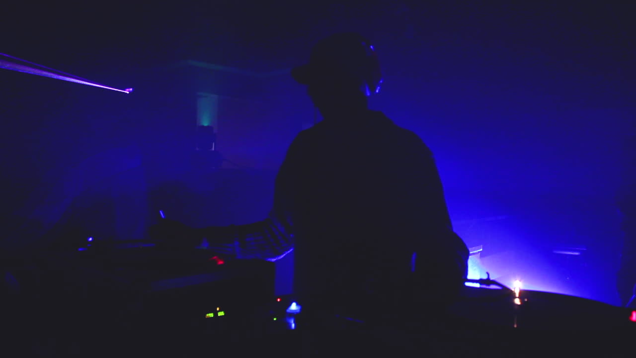 un dj en un rave clandestino hace girar una mezcla ecléctica de música de baile trance de ondas de graves profundos electrónicos para los kandi kid rave babes and shufflers