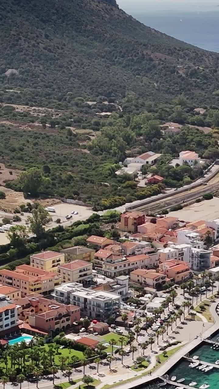 Kystby i Sardinien med både og bakker i baggrunden